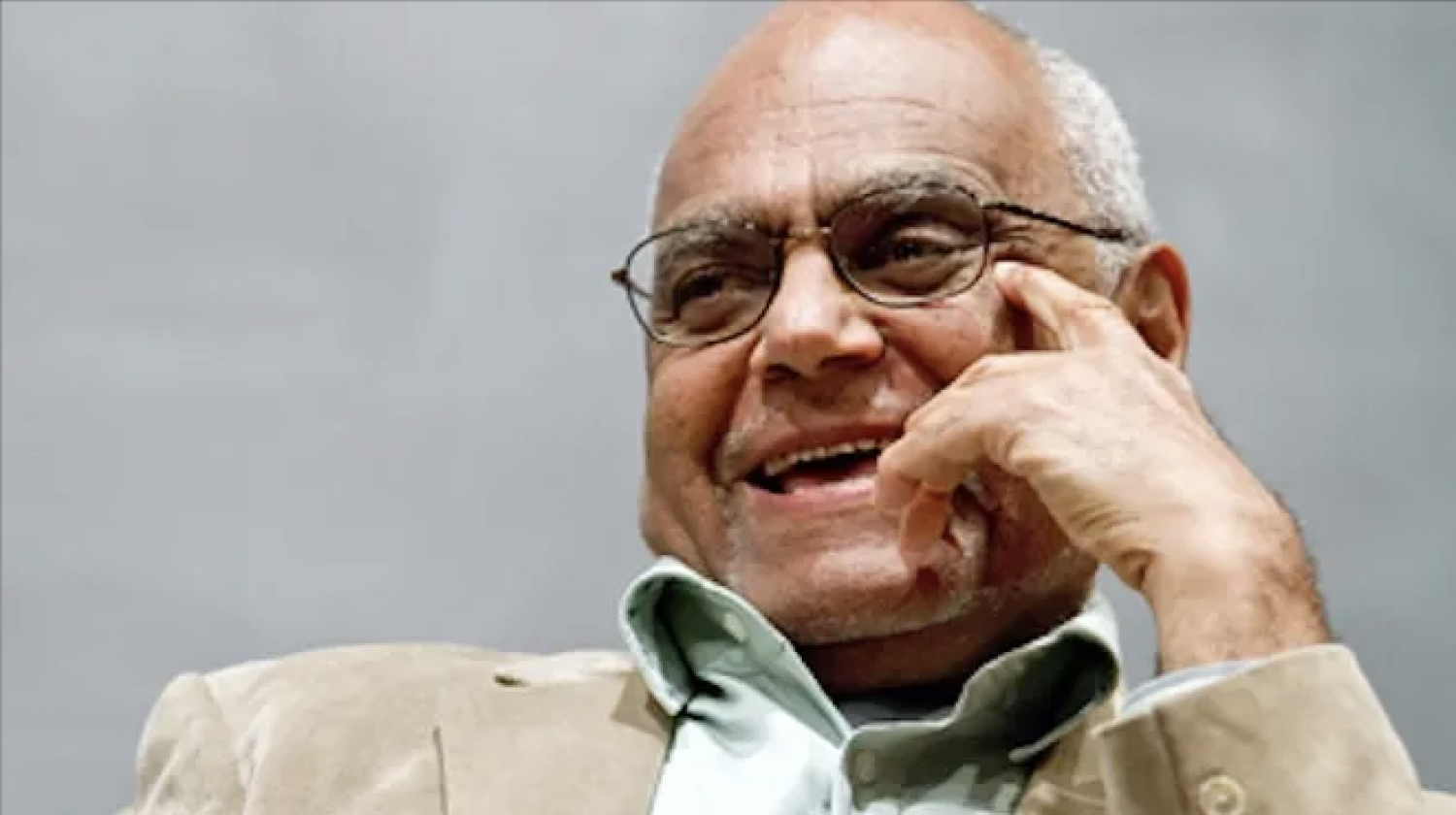 Photo of Robert Moses smiling with hand on his face.