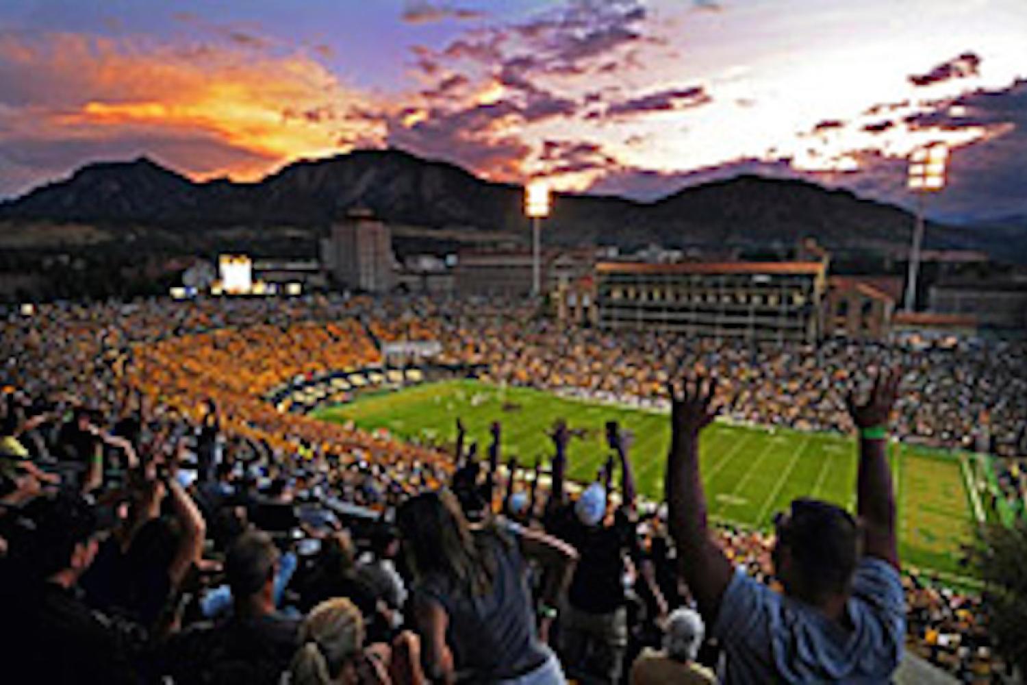 Cheering fans in footbal stadium at sunset