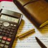 calculator, notebook and pen