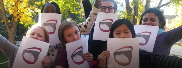 People holding signs of smiling mouths up to the lower 1/3 of their faces.