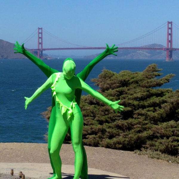 Two people in green suits posing with the Golden Gate Bridge in the background in San Francisco, California, United States