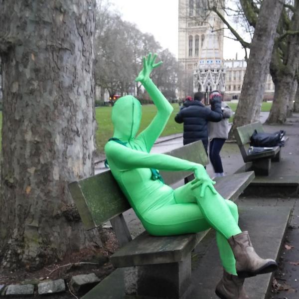 Person in a green suit on a bench in London, England