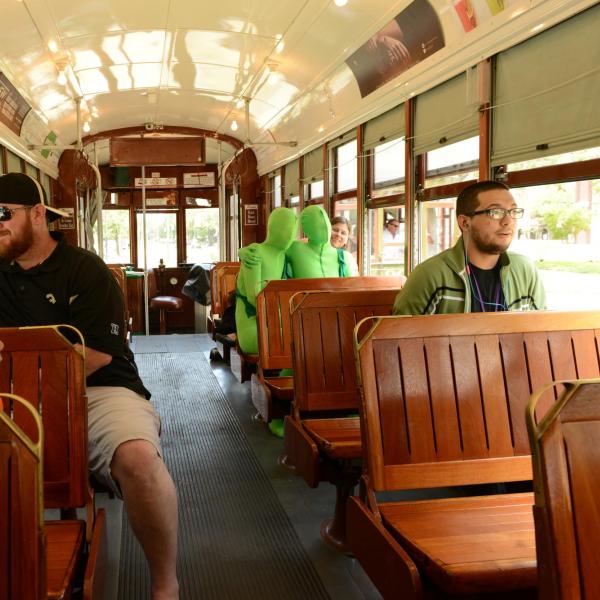 Two people in green suits riding a trolley in New Orleans, Louisiana, United States