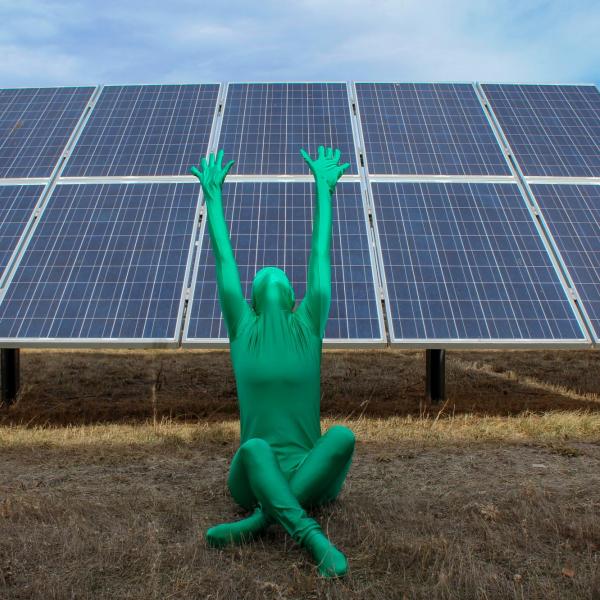 Person in a green suit in front of solar panels