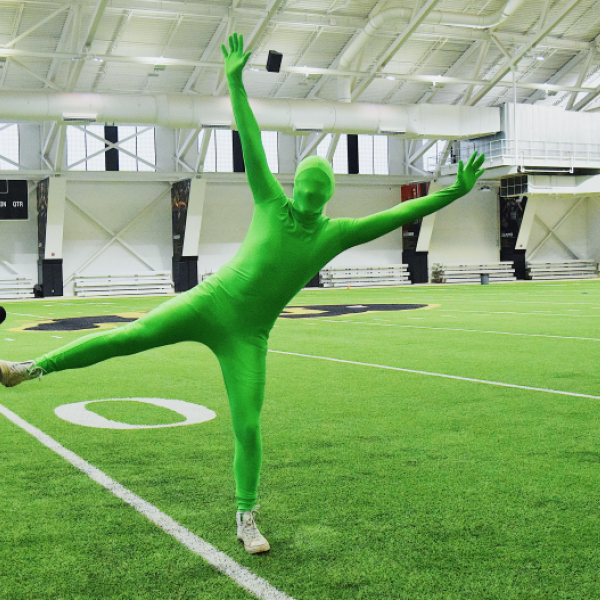 Person in a green suit at the campus indoor practice facility