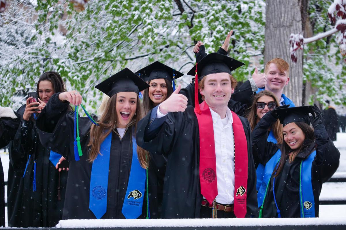 graduating students give thumbs up at commencement