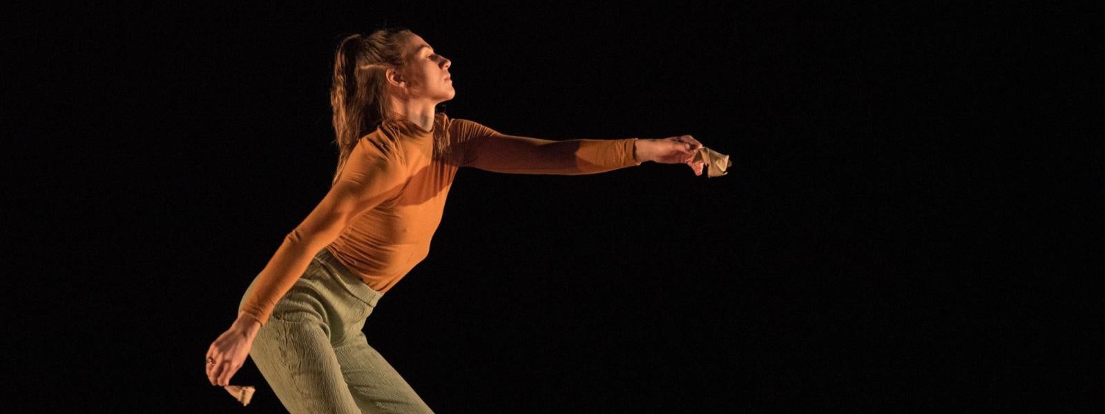 A dancer holds her hand out to the side