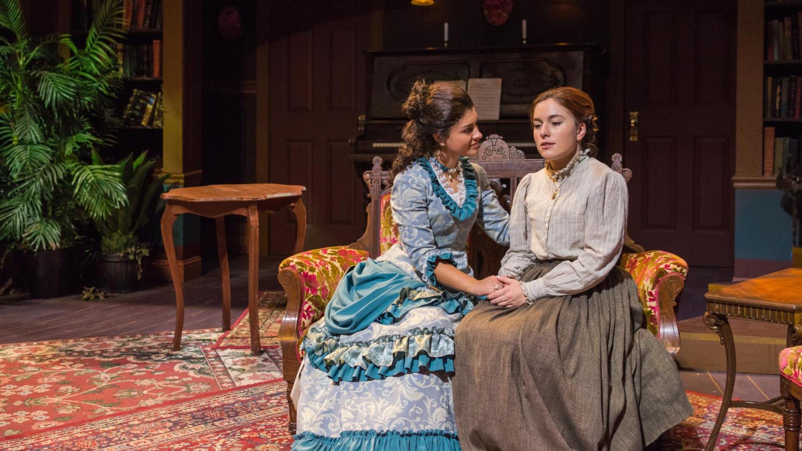 two women speak to each other on a sofa