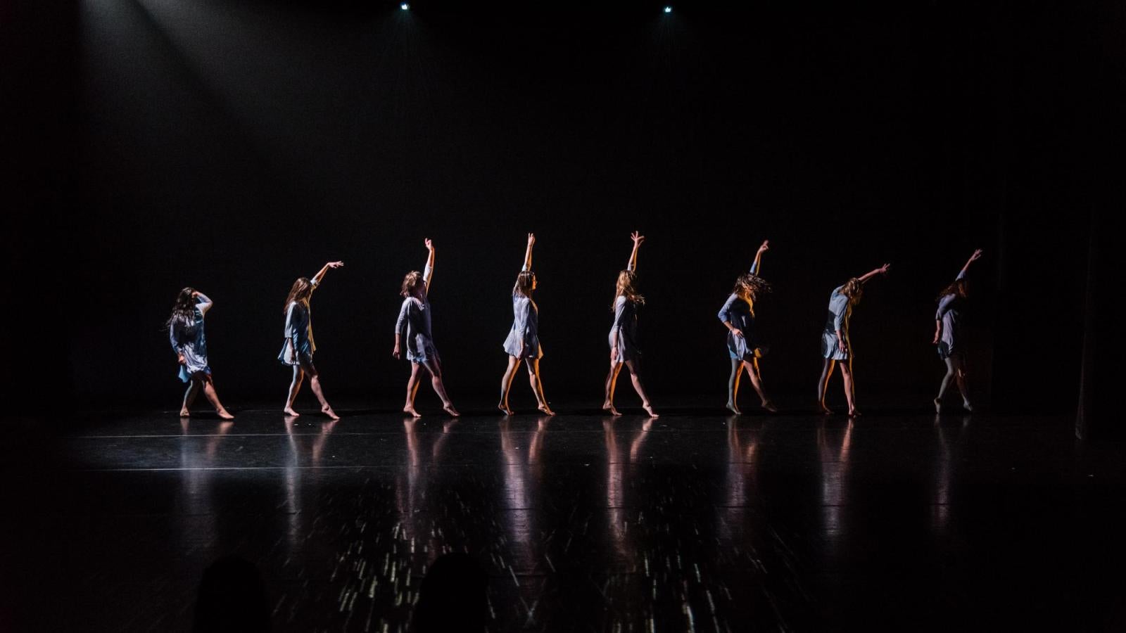 Eight dancers in a line on stage