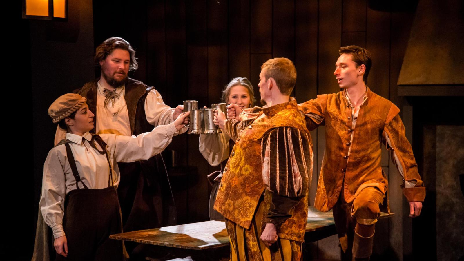 Five student actors cling their glasses together