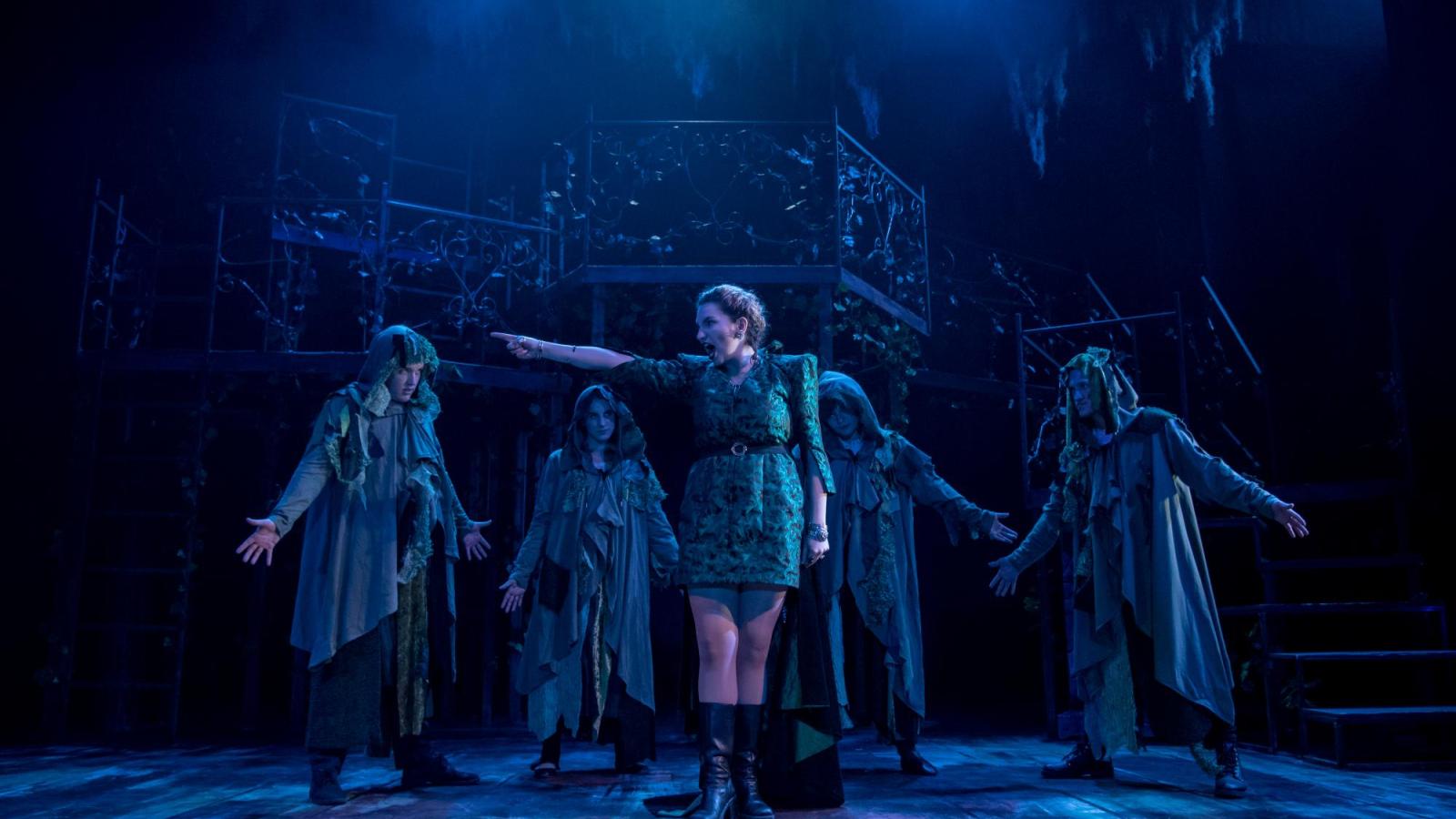 one student actress points to the left while a group of others surrounds her