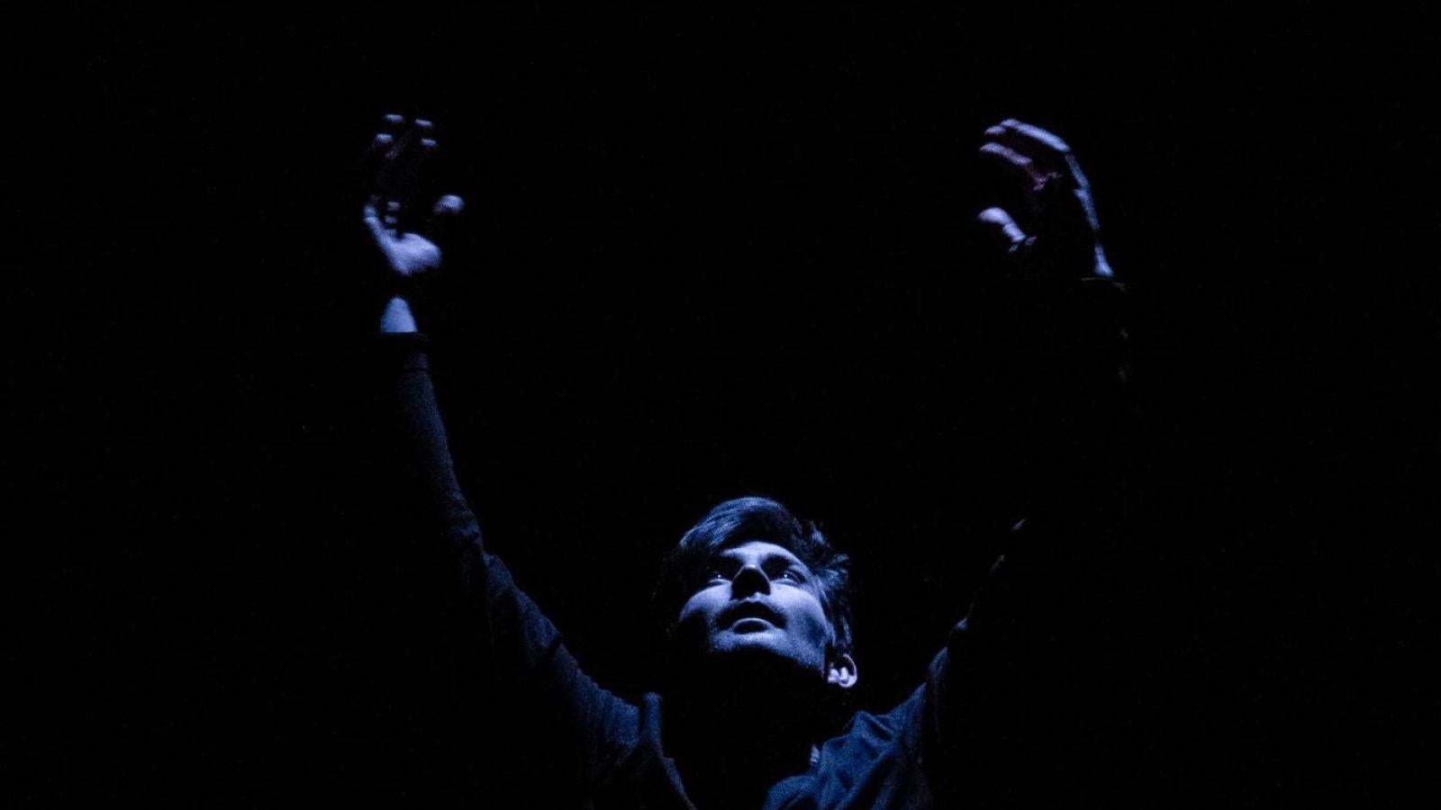 A male dancer reaches up