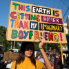 climate change sign reading "this Earth is getting hotter than my imaginary boyfriend"