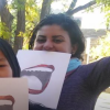 Fahmy holding paper sign with open mouth on it in front of her face