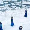 dancers in blue perform on snow and ice