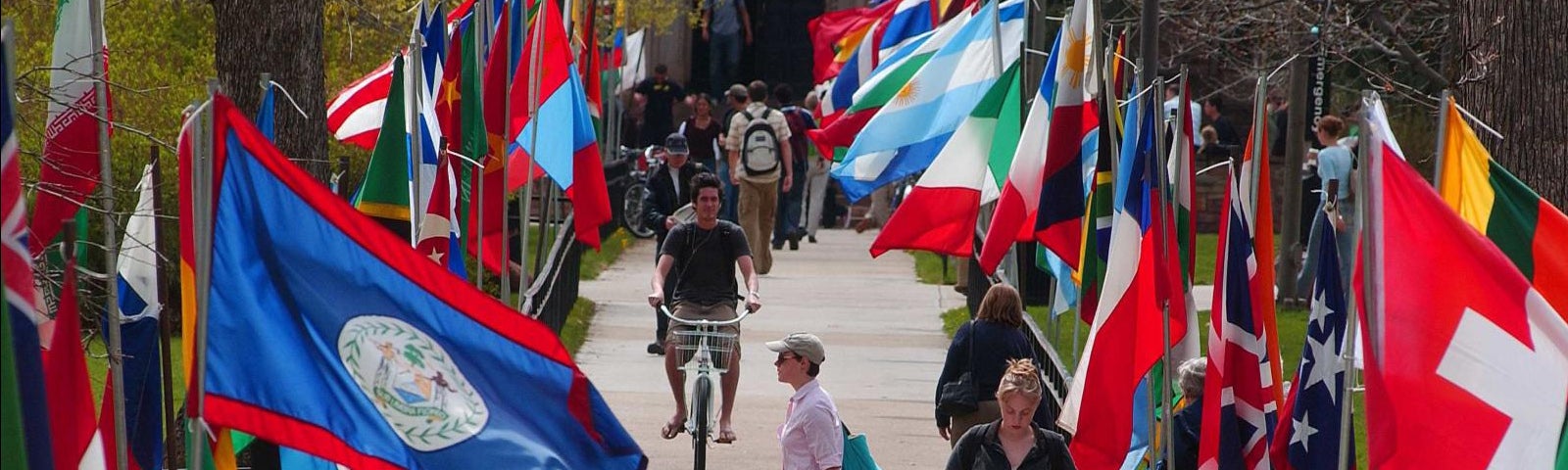 people walking between flags of the world