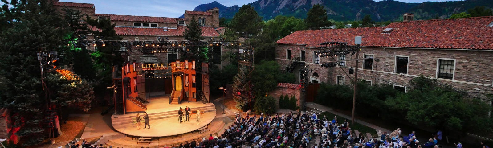 people watching a play in an outdoor theatre