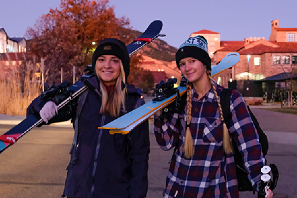 students boarding a ski bus with snowboards