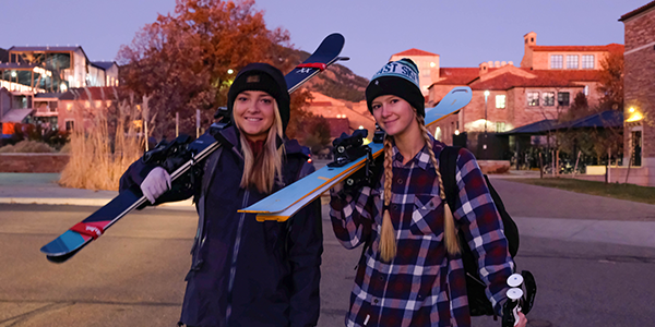 students boarding a ski bus with snowboards