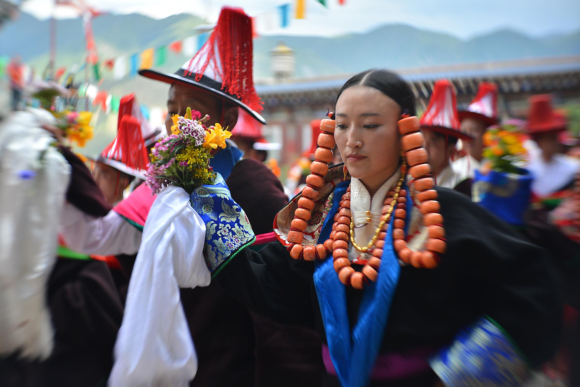 During the “Dance” or Gar (གར) portion of the festival, men and women wear fine clothes and jewelry and dance together in a swirling pattern. They eventually fill the entire courtyard.