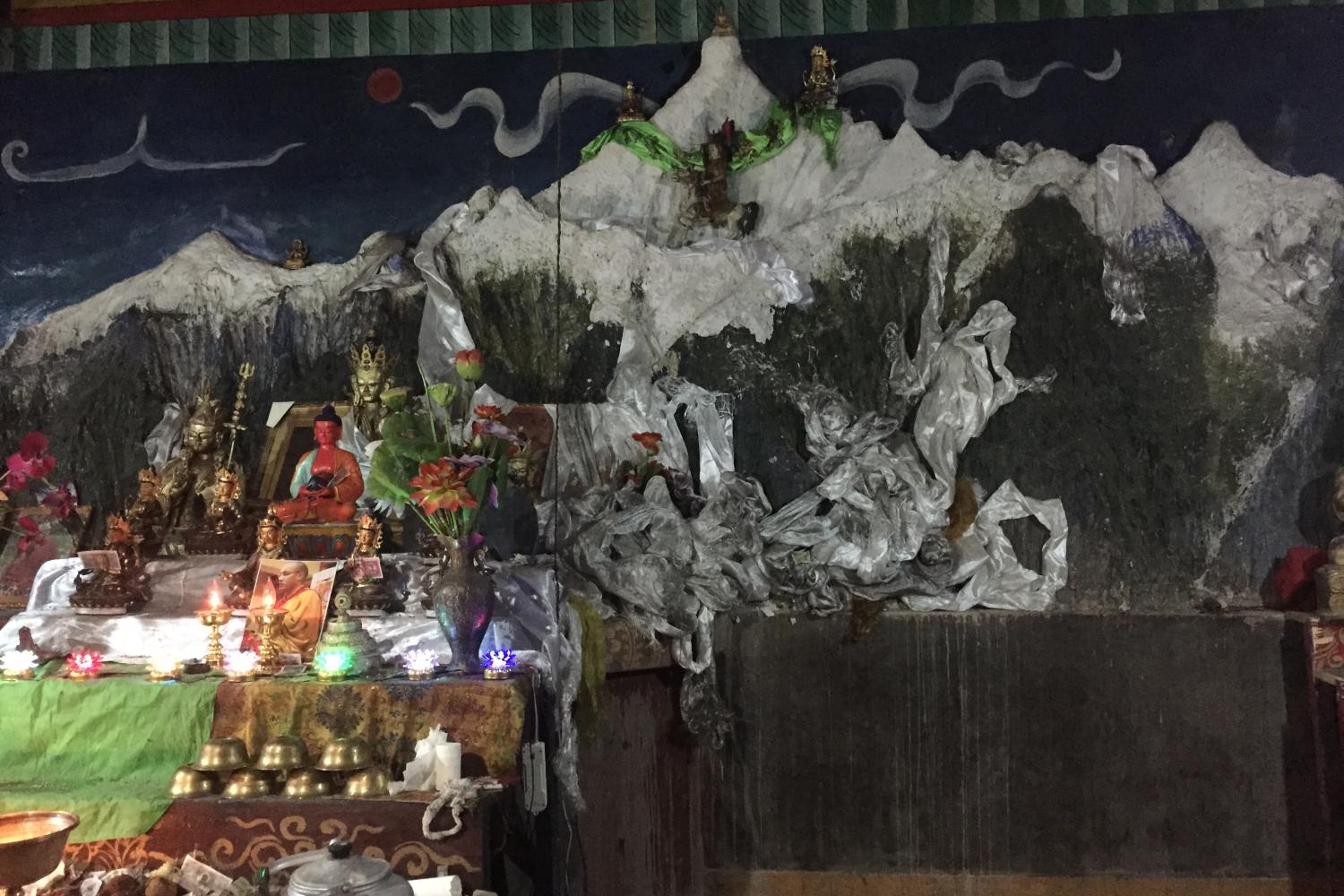 Sonam Norbu built a small temple, in which is this wall sculpture of the entire mountain range around Khawakarbo, to atone for his past sins as a hunter. It is located by a remarkable old grove of ancient cypress trees on the banks of the Mekong River at the edge of Bu Village.