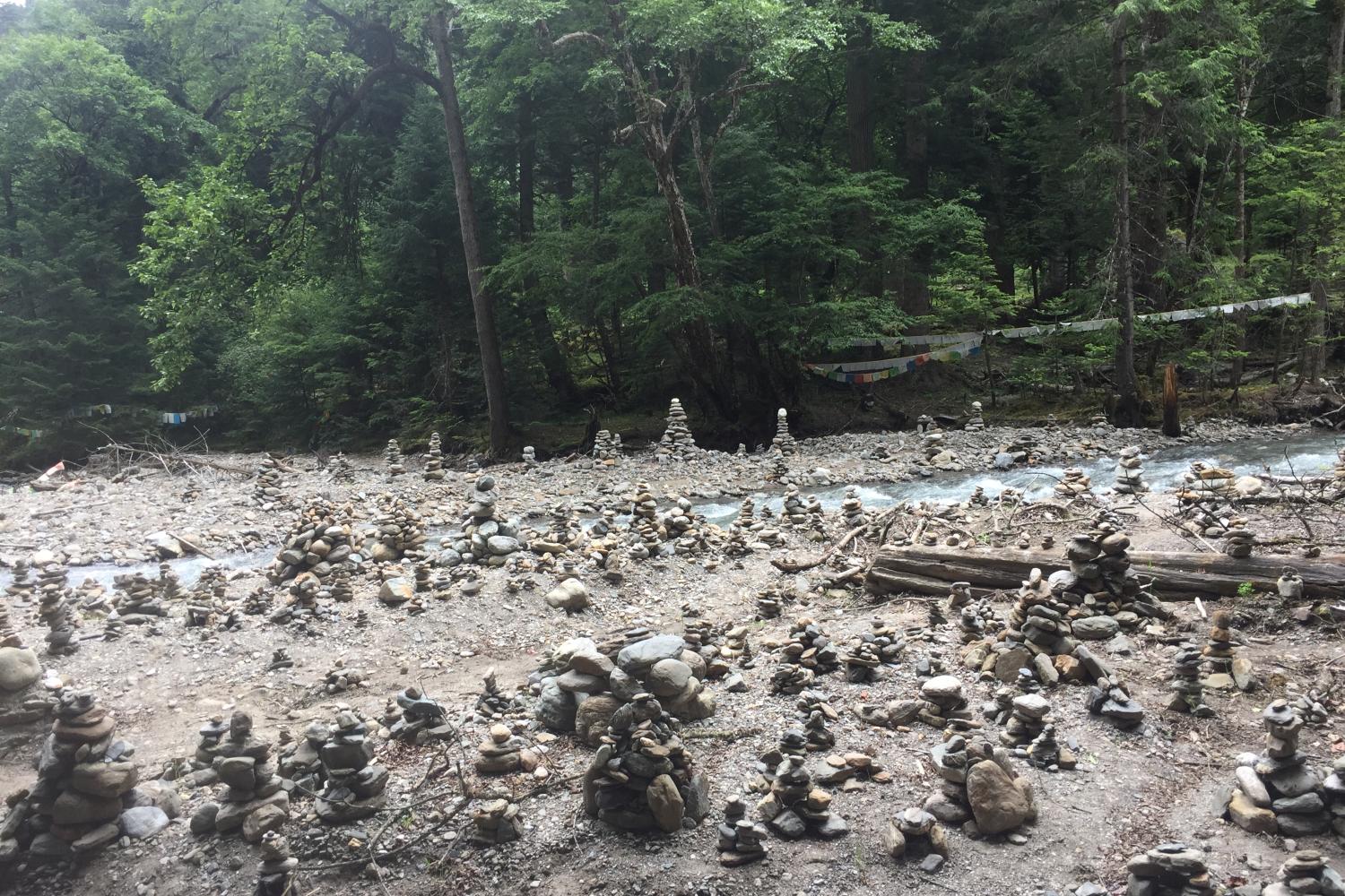 Cairns along Yubeng River on the way to the sacred waterfall. Though generally a marker of propitiation of territorial deities, some cairns in the area are piled in the shape of small houses, which are variously said to be just like other cairns or symbolic of building a home for one’s next life.