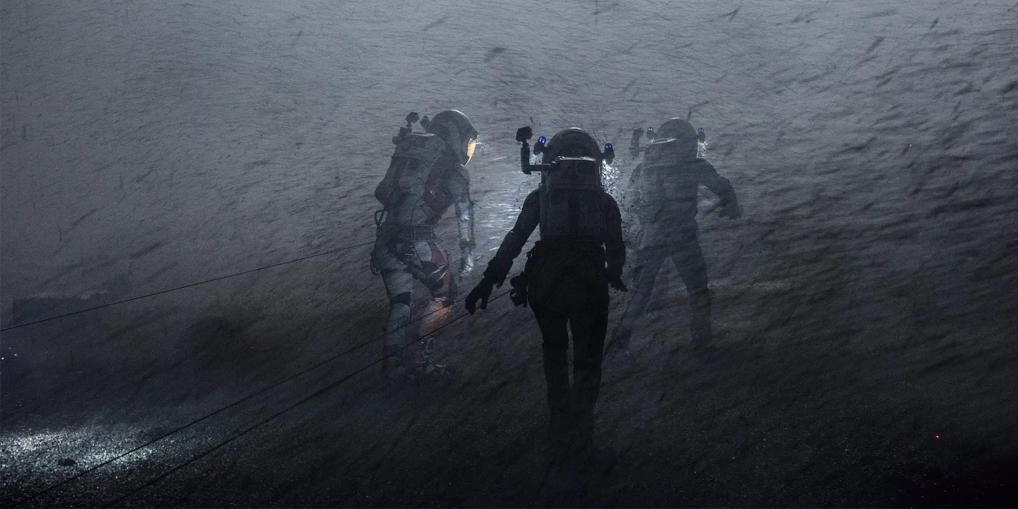 Movie still showing three astronauts with debris flying all around htem