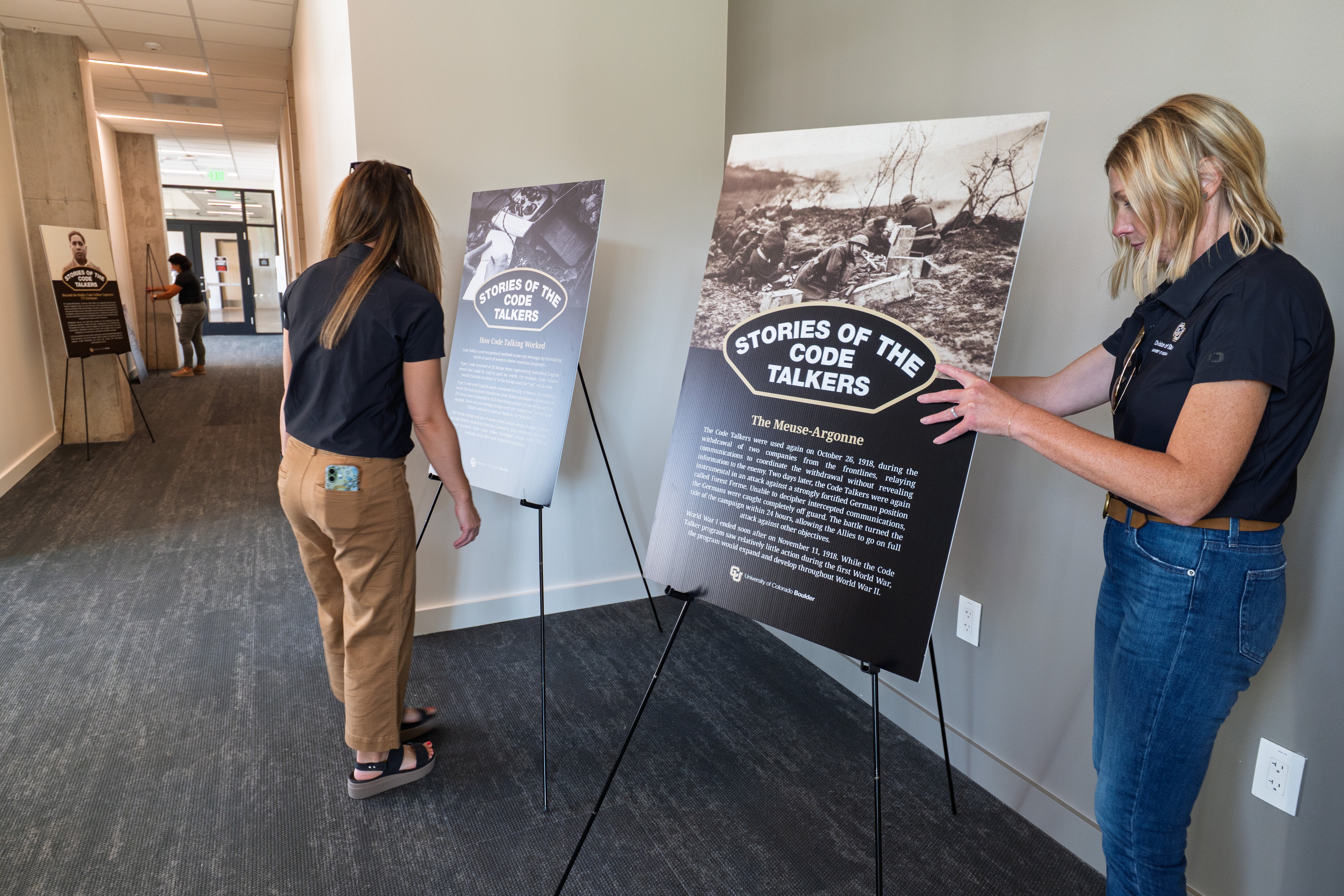 Staff place Code Talker explanatory historic posters ahead of the new Code Talker Hall dedication ceremony.