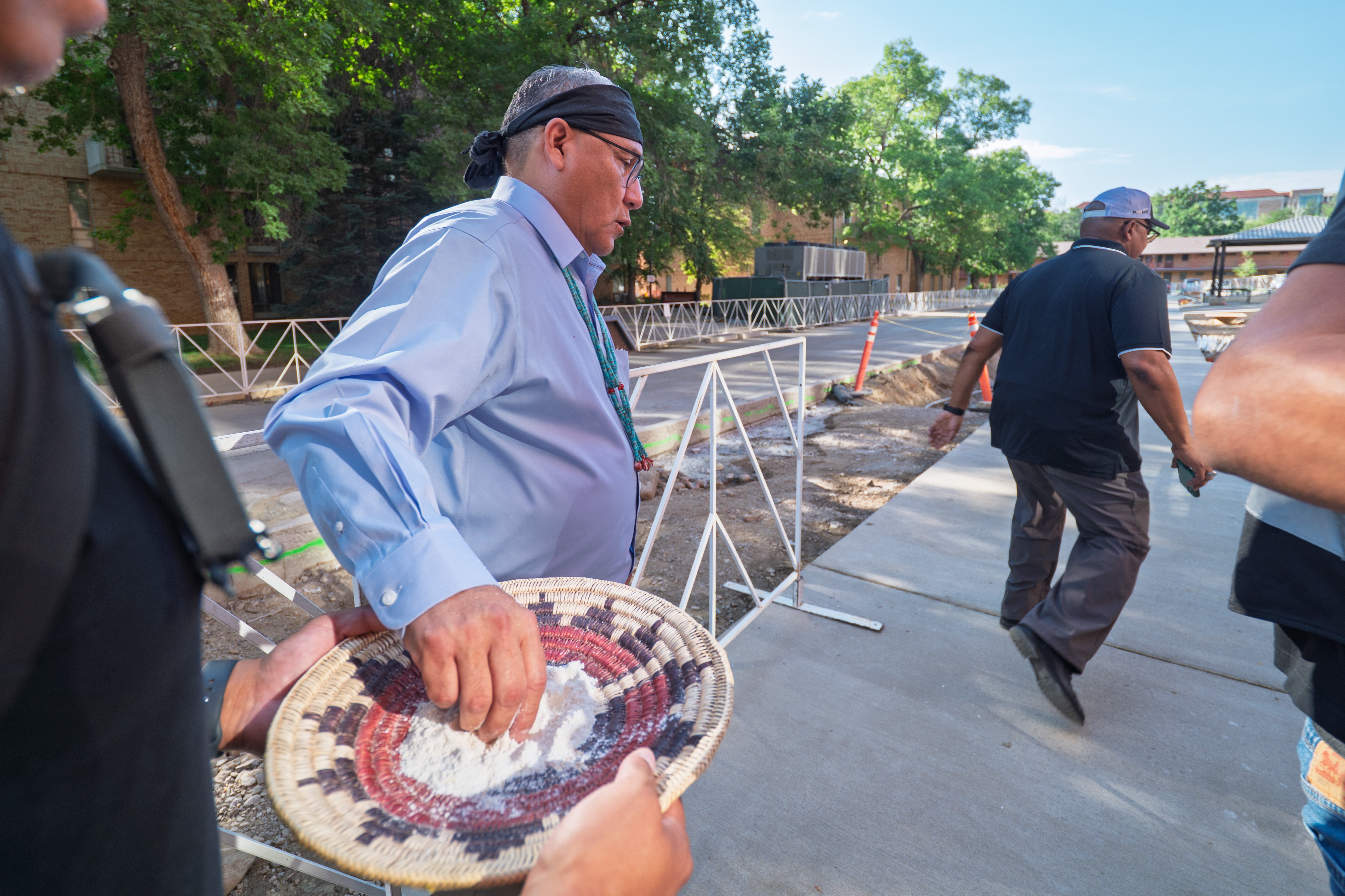 Justin Jones of the Navajo Nation sprinkles ground corn around the new Code Talker Hall