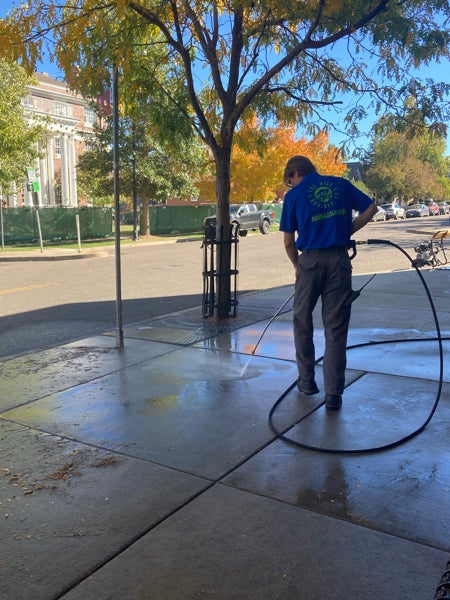 Ambassador power washing a sidewalk on the Hill