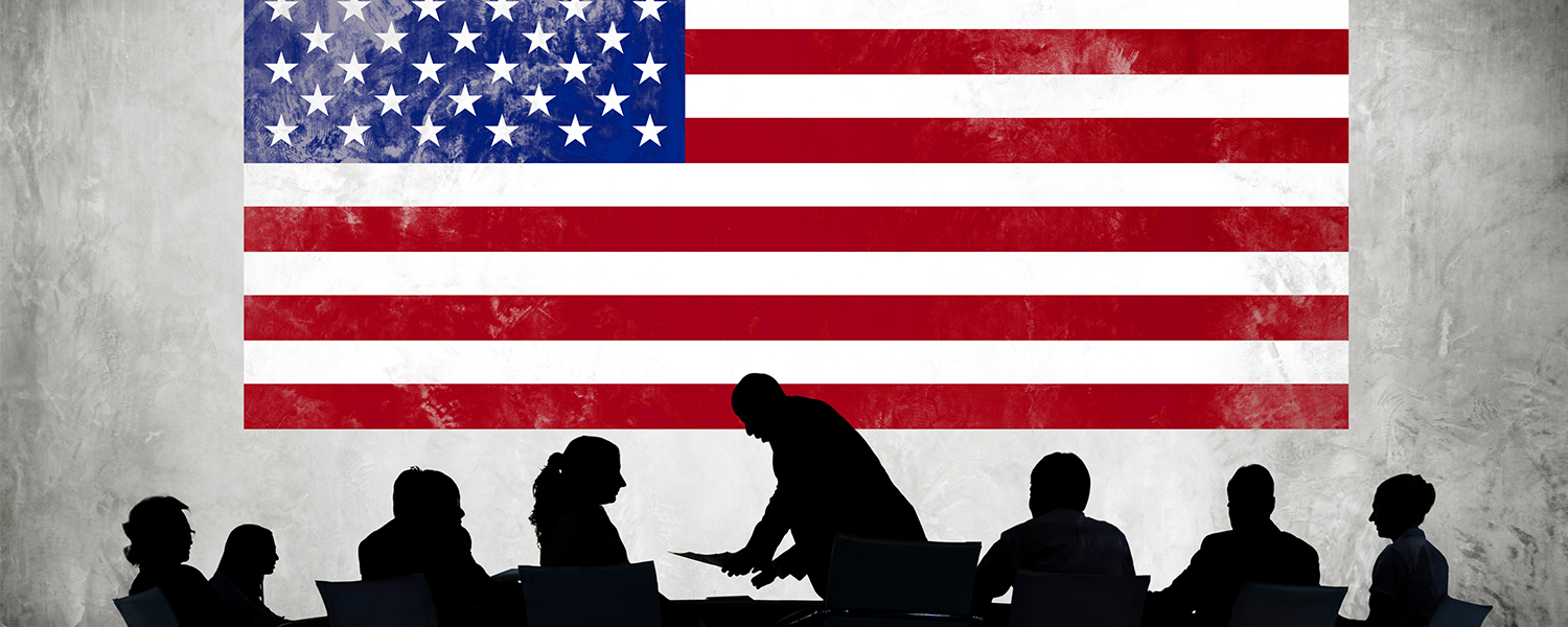 American flag with silhouettes of business people working