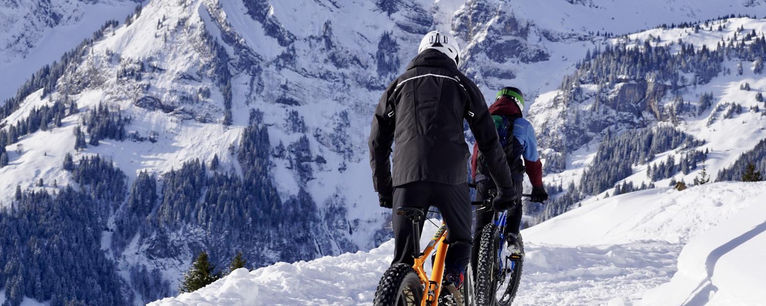 People mountain biking in snow