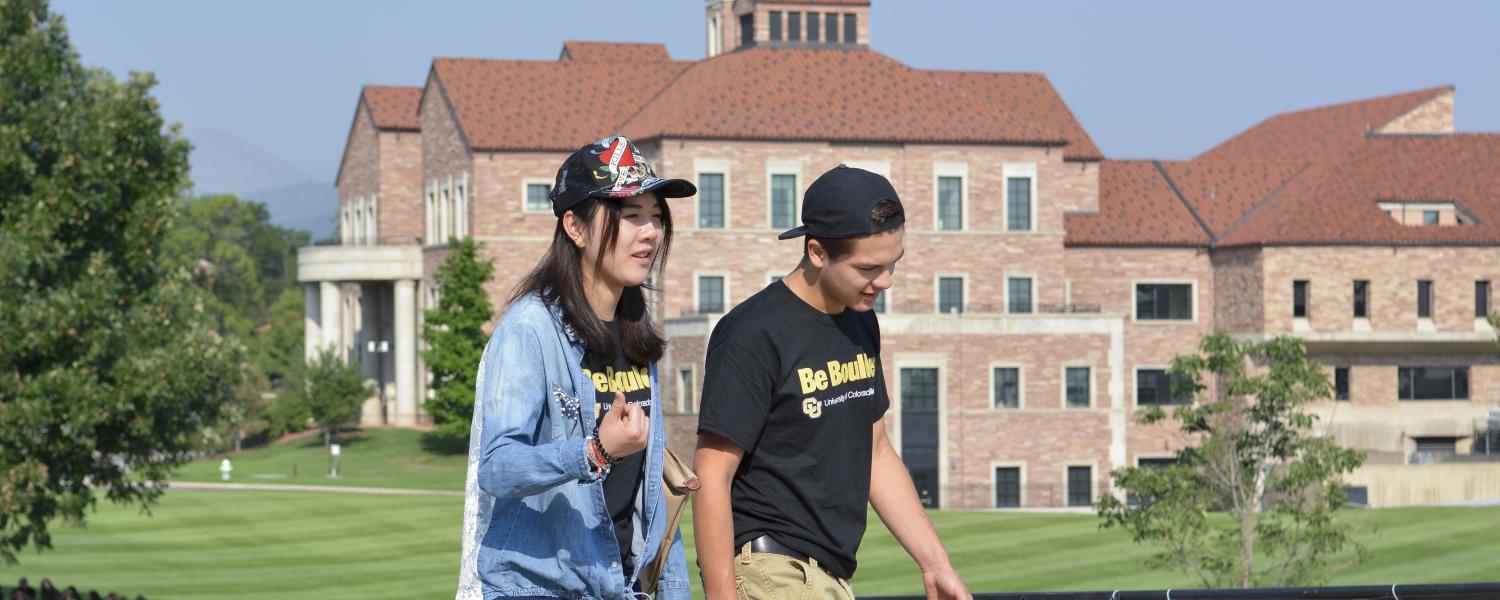 Students walk on campus near Leeds School of Business