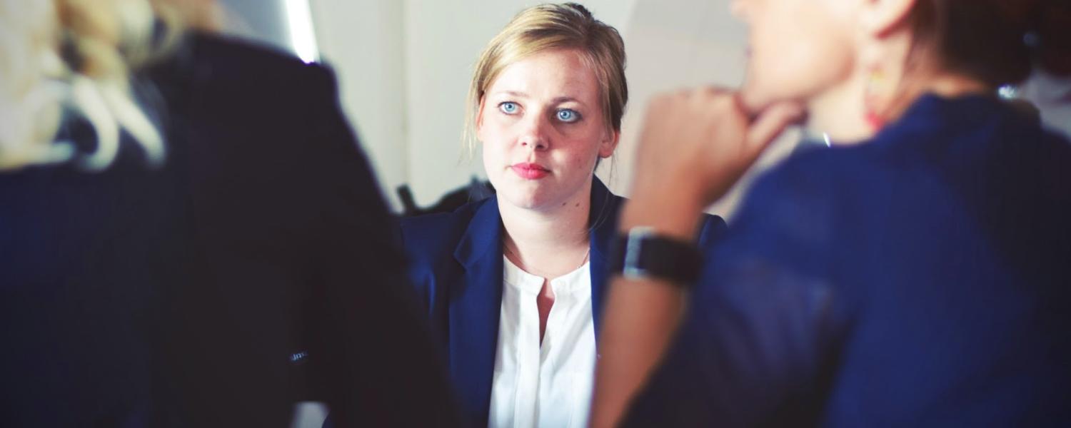 Woman listens to interviewers talk