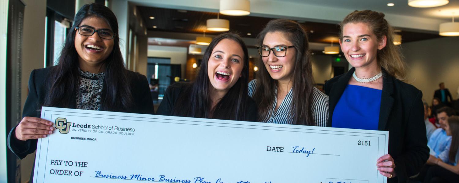 Business minor business plan competition winners pose with giant check