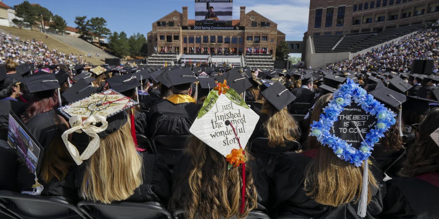 students sit on Folsom Field during 2018 commencement ceremony