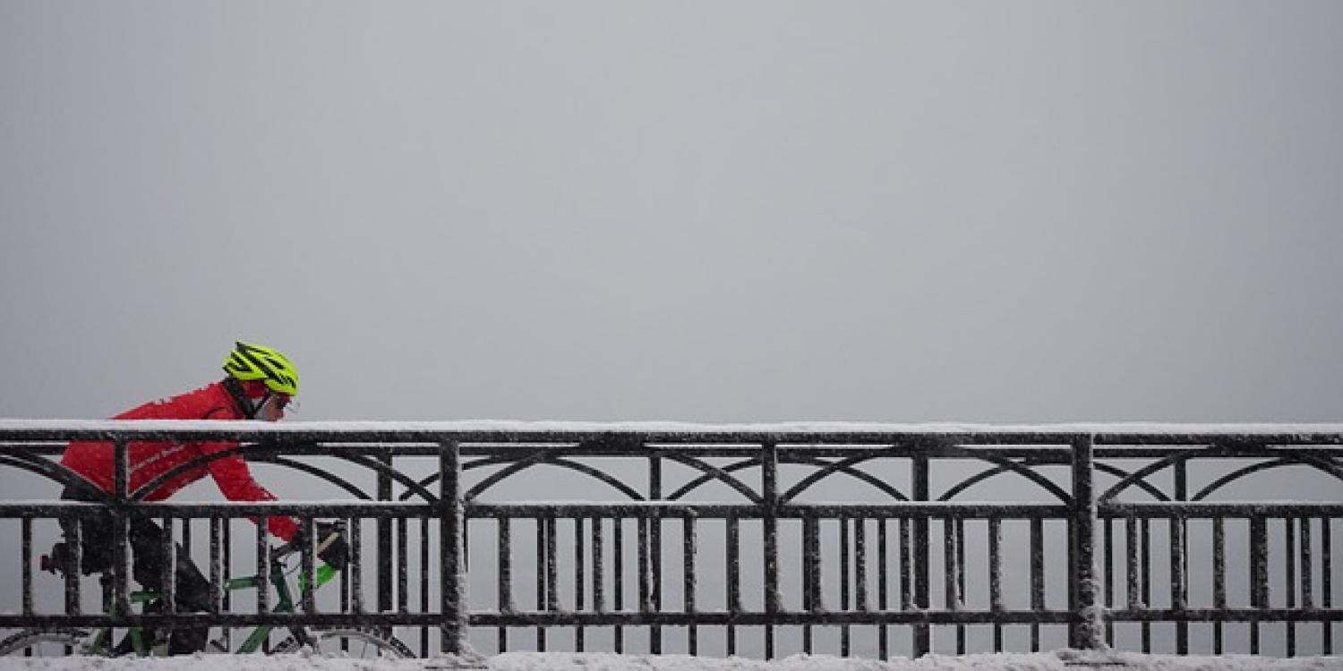 Biker crosses bridge in the winter