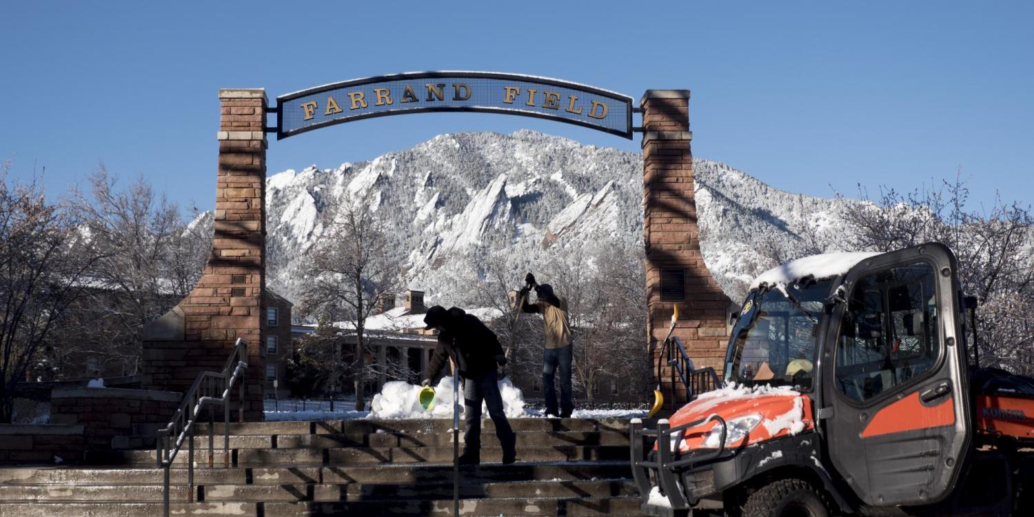 CU Boulder facilities management workers clear snow and ice from the steps to Farrand Field