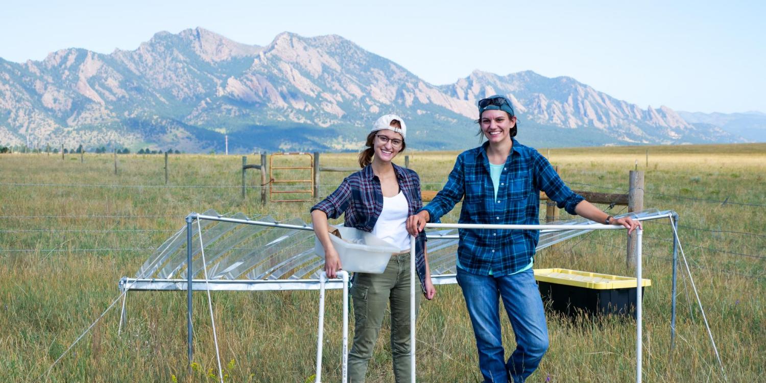 Graduate student Julie Larson and undergraduate Emily Koke in grass