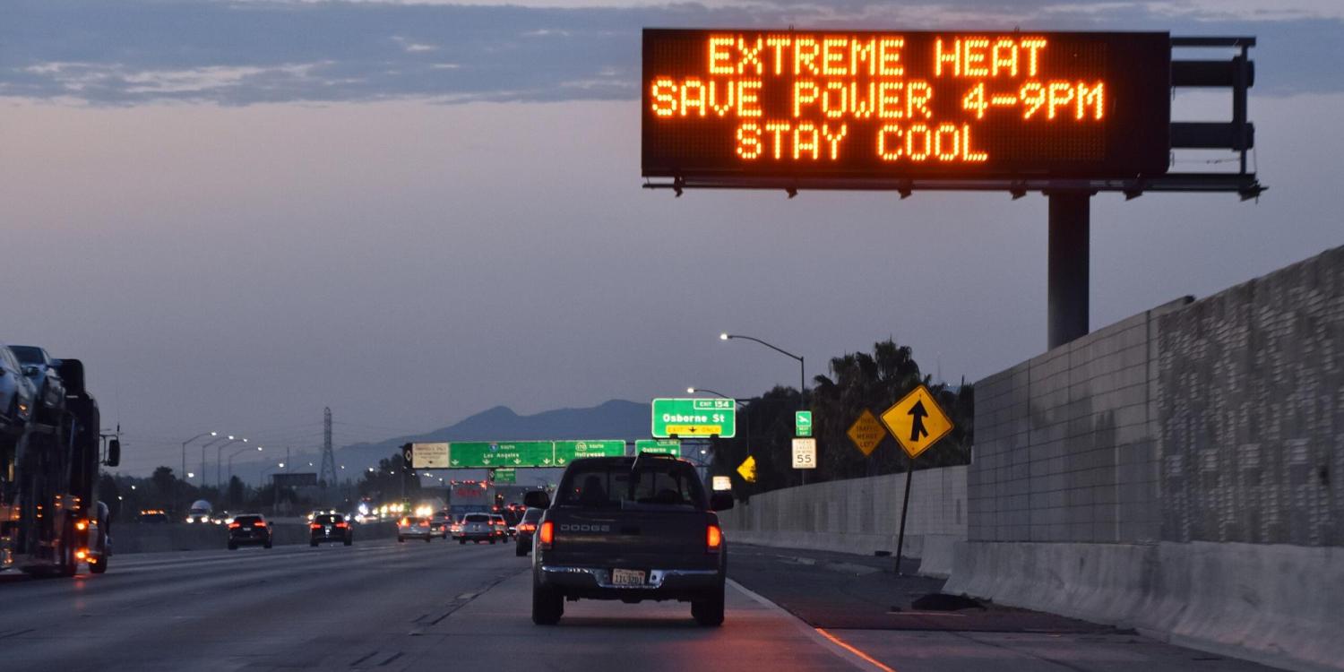 Highway road sign reads: "Extreme heat. Save power 4-9 p.m. Stay cool."