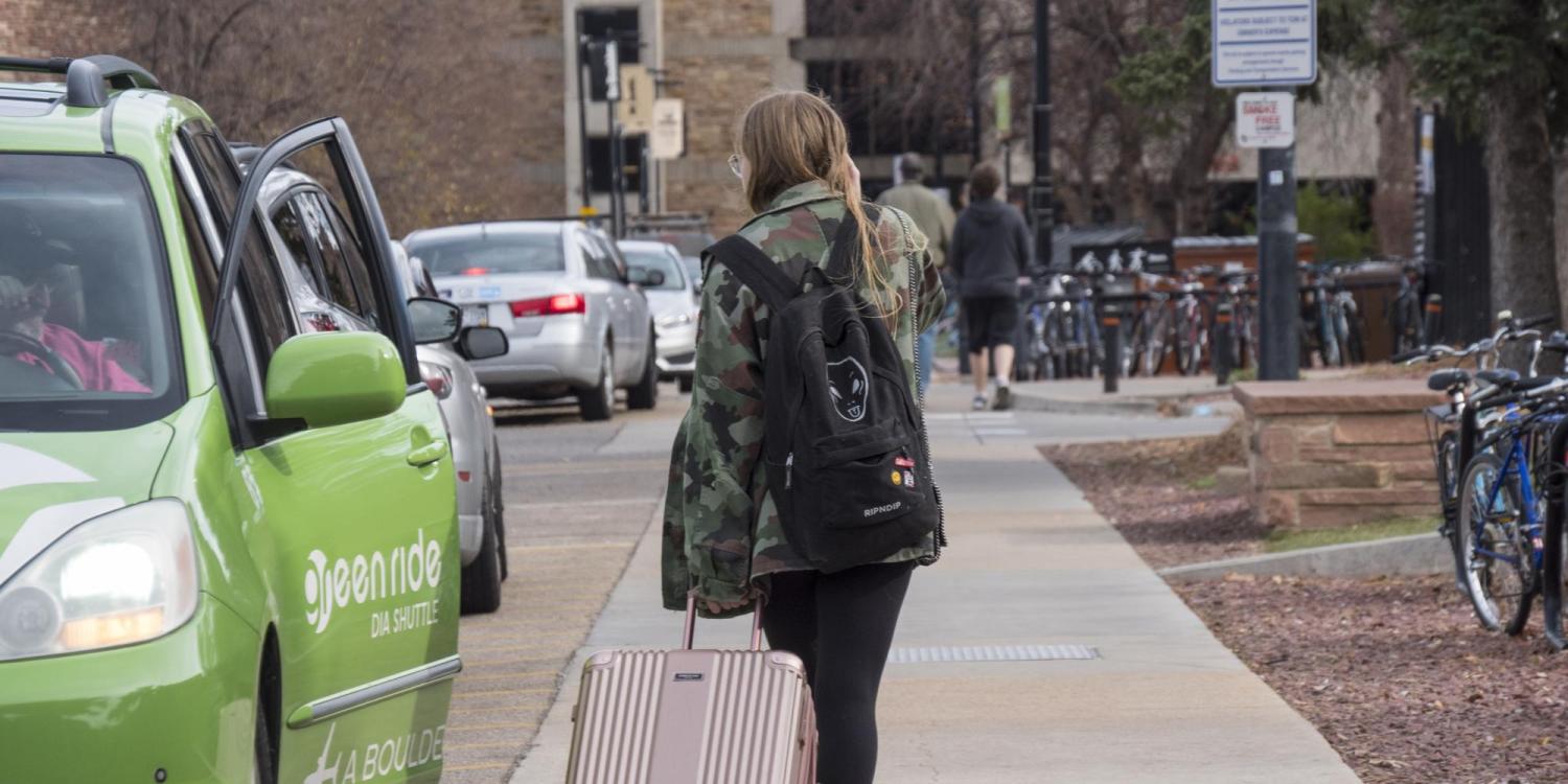 Student leaving campus with suitcase