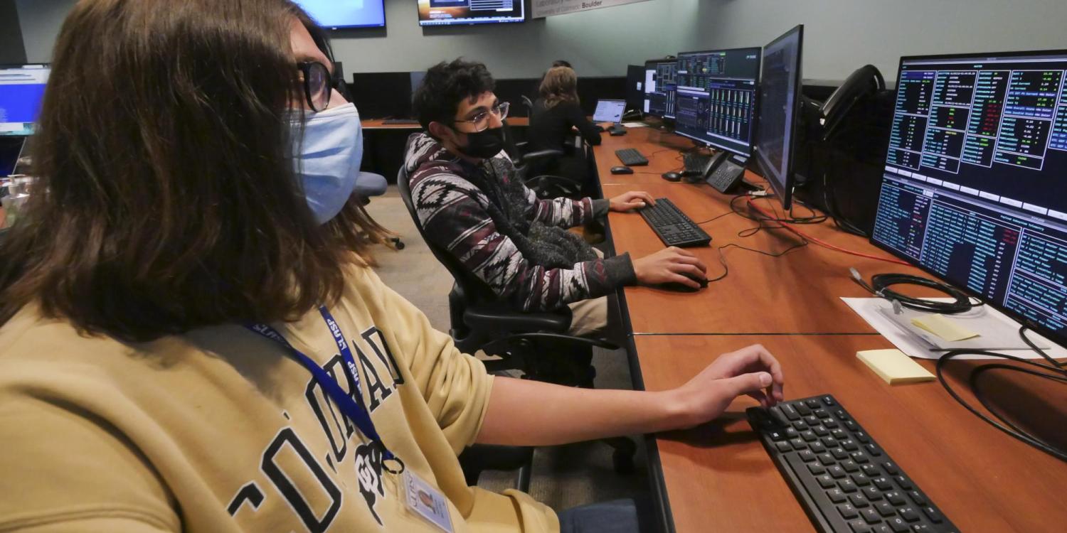 CU Boulder undergraduate students, left to right, Adrian Bryant and Rithik Gangopadhyay work in the mission operations center for IXPE. 