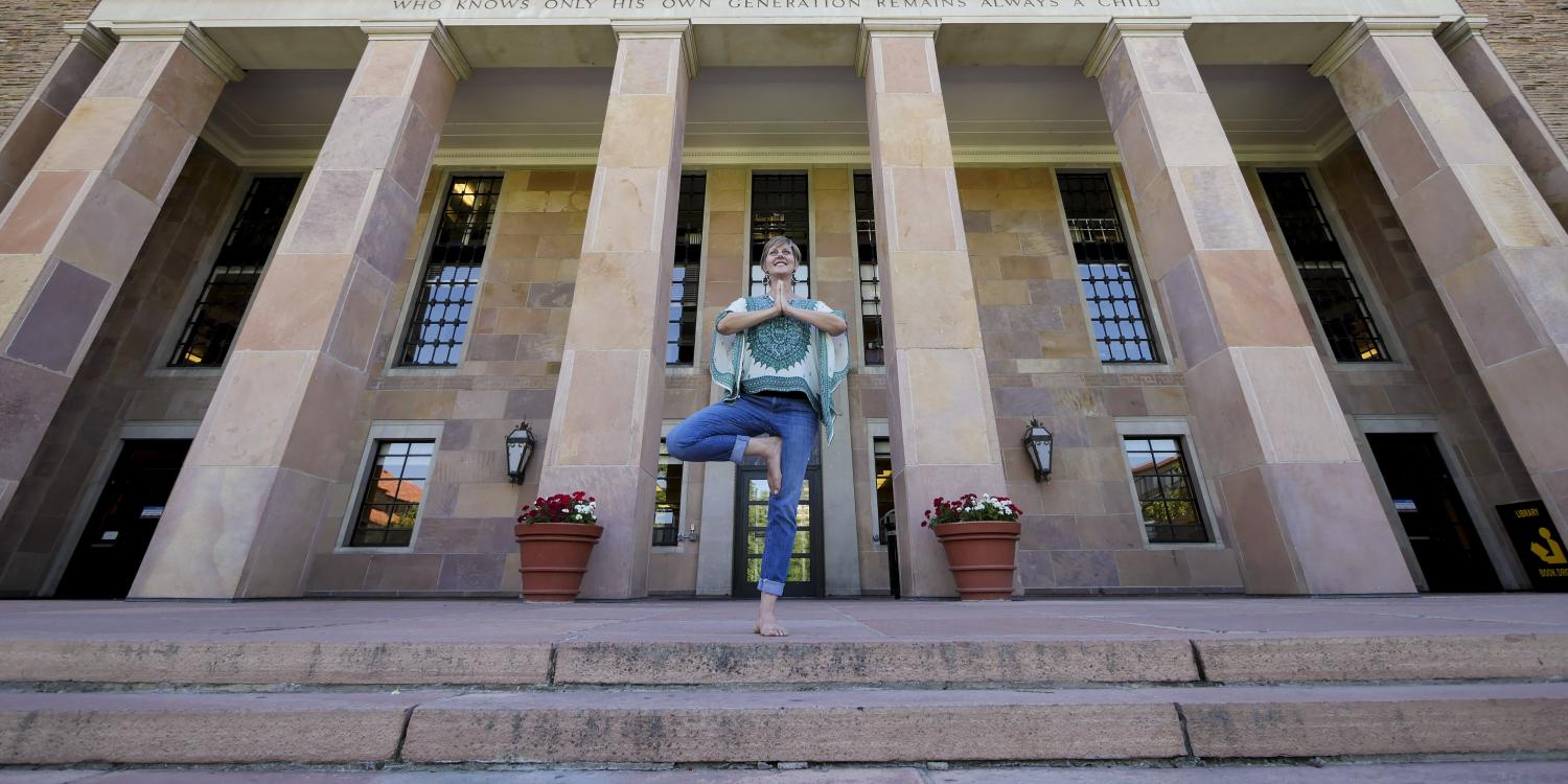 Lori Hunter demonstrates yoga pose in the steps of Norlin Library