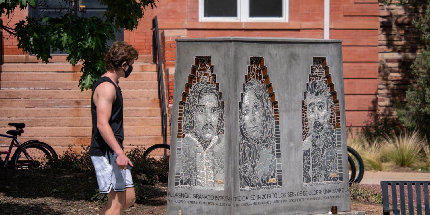 A person walks by the Los Seis de Boulder sculpture on the CU Boulder campus.