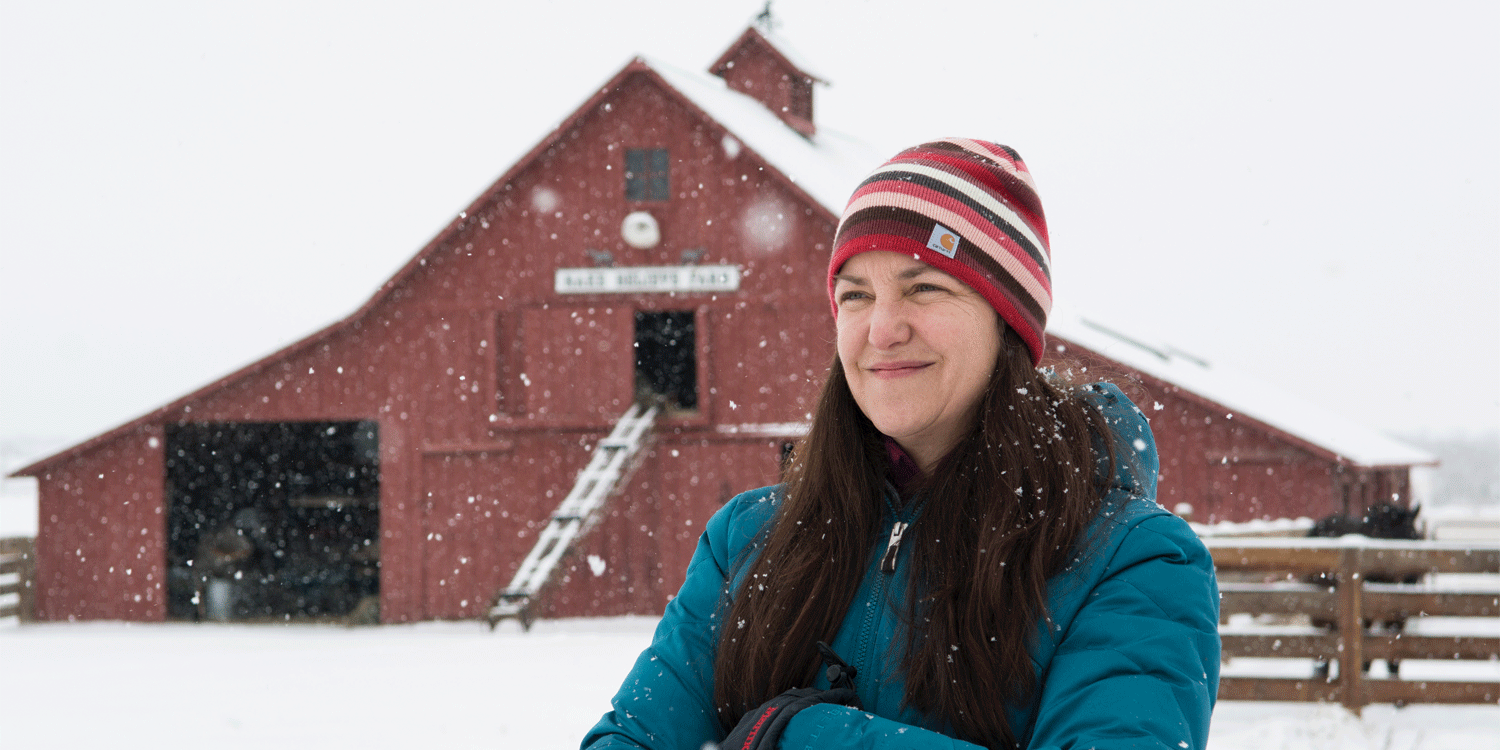 Rebecca Safran standing outside in the snow in front of a barn