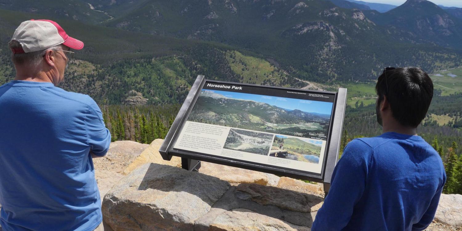 Two people overlook scenery at Rocky Mountain National Park