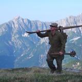 Chris Anthony carries a pair of World War II-era skis up the flanks of Mount Mangart