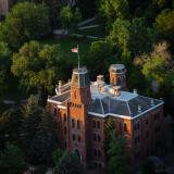 Old Main peeks through tree tops.