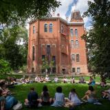 Students sit in a circle in the grass