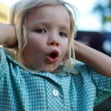 Little girl holds her hands over her ears